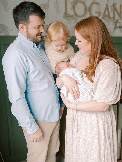 mom-holding-newborn-and-toddler-in-nursery