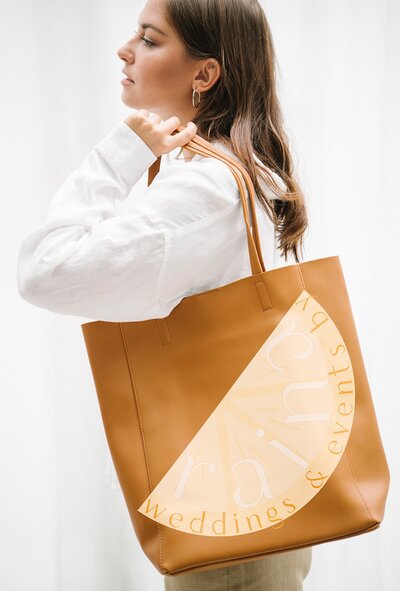 mockup of girl carrying a leather bag with a branded logo for her small business