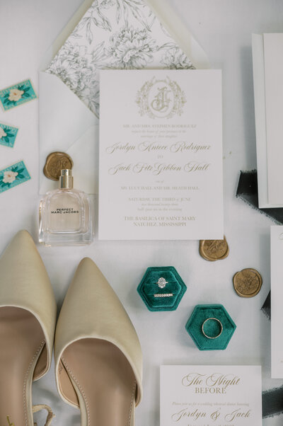 flat lay of emerald and gold wedding details