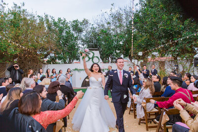 Orange County wedding photography of a bride and groom walking the wedding aisle