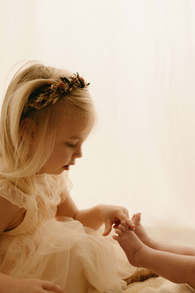toddler tickling newborn siblings feet in murfreesboro tennessee newborn studio