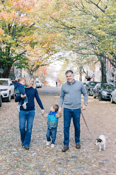 Family walking down cobblestone street in Alexandria during family photo session