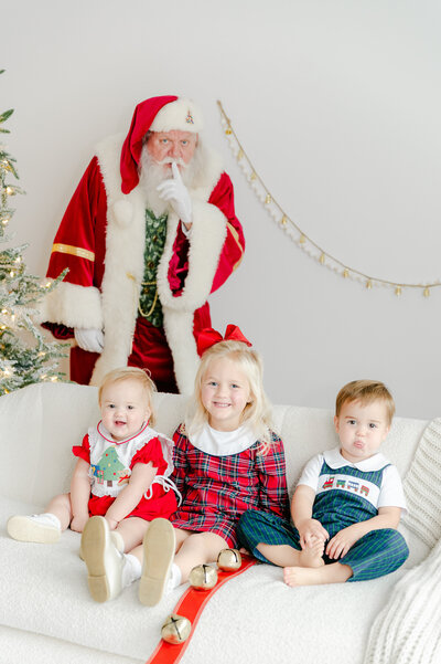 Boys in Christmas Pajamas with Santa sneaking in behind them