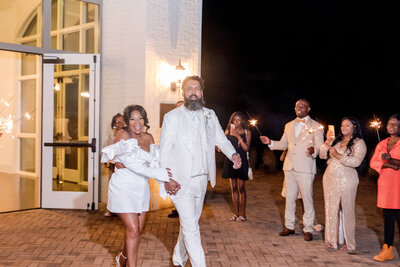 Newlyweds making a stylish wedding send-off under the night sky at a luxury wedding venue.