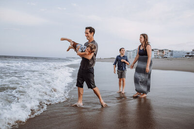 A sample image from Philadelphia wedding photographer Daring Romantics. A family plays at the beach.