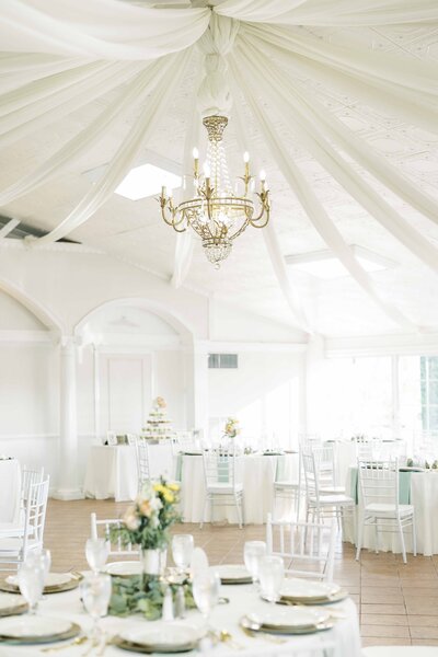 a ballroom decorated with white decor for a wedding