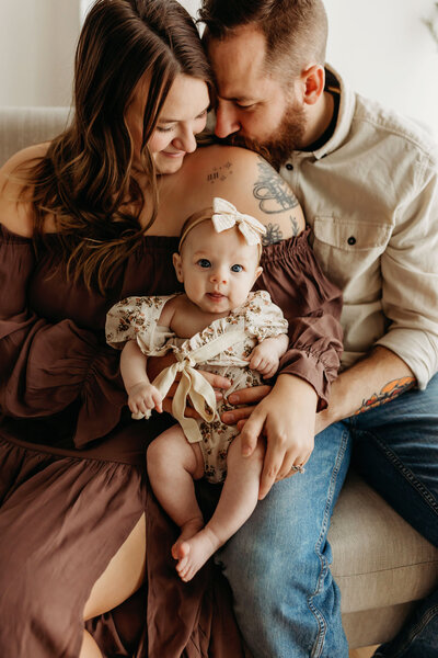 A family snuggles up with their baby in a natural light studio photographed by a Vancouver Washington Photographer