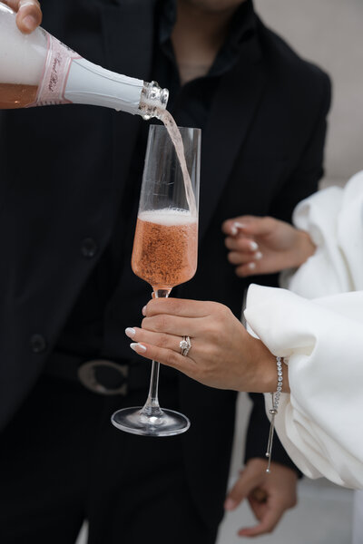 Groom pouring champagne for himself and his bride during their intimate Atlanta elopement.