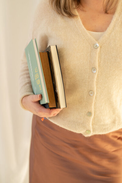 Business mentoring. Vrouw met drie boeken onder haar arm.