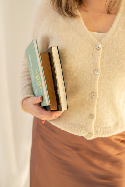 Drie boeken geklemd onder arm