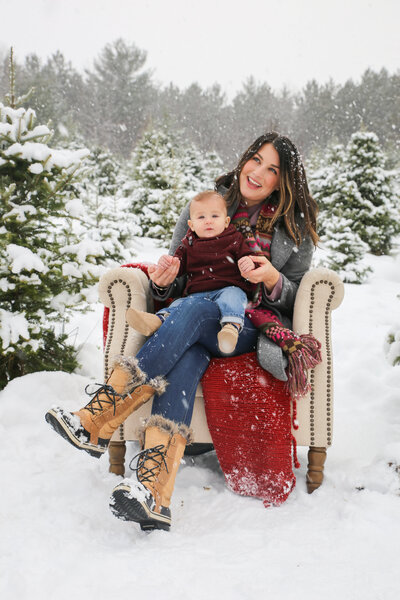 Mom with baby on chair in snow | Family Photography Session