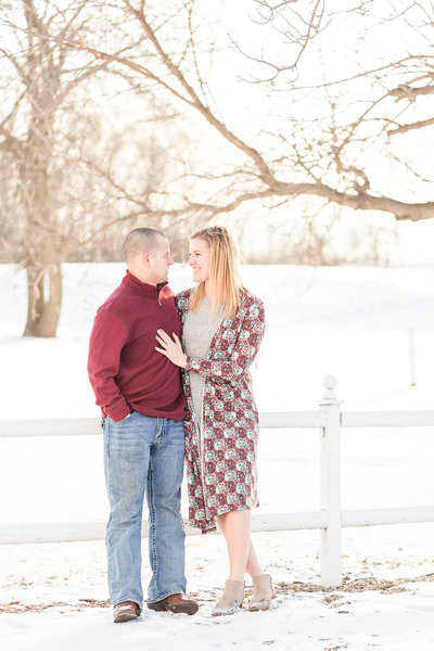 Engaged couple holding hands and laughing in black and white