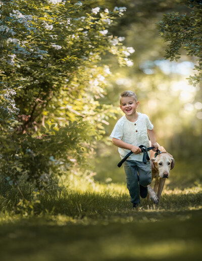 Boy with his dog running at the park by Iya Estrellado, a Virginia Beach photographer.