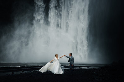 bride and groom infront of Icelandic waterfall