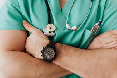 doctor folding arms in green scrubs