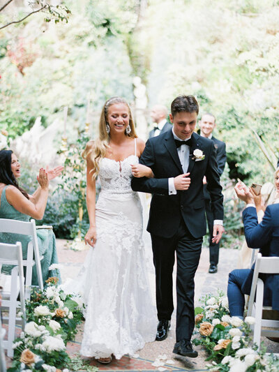 Houdini Estate Los Angeles Wedding Photographer Bride and Groom walking down the aisle arm in arm smiling while guests clap around them