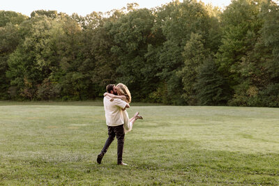 Groom dipping bride in front of a hot air balloon.