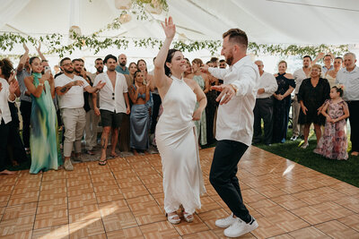 bride and groom holding hands while their bridal party is standing around them