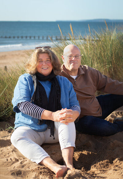Couple sit in the sand dunes together