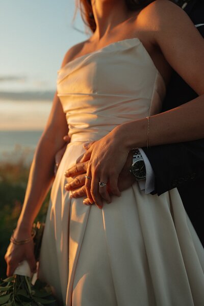 bride and groom embrace on beach at wedding in pei