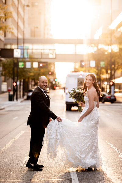 Immerse yourself in the breathtaking beauty of Brooke and Jon-Erik’s sunset photo session in Downtown Cincinnati. Captured against the vibrant backdrop of the city's bustling streets bathed in golden sunset light, this stunning image showcases the couple’s romantic embrace. The warm hues of the sunset perfectly complement their joyous expressions, creating a picture-perfect moment of urban romance. Ideal for couples dreaming of capturing their love story amidst the beauty of cityscapes at dusk.