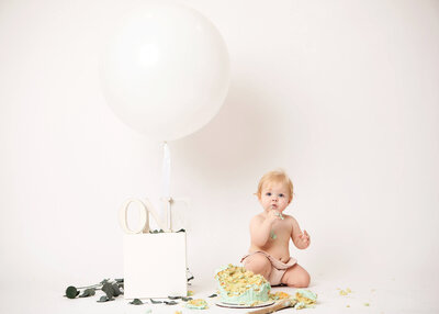 Baby girl with cake doing a cake smash in Woodland Hills by Los Angeles children's photographer