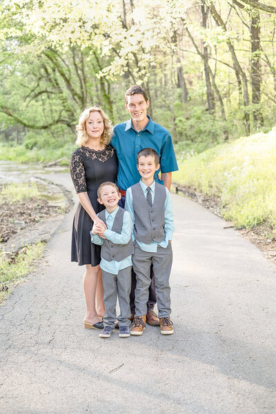 Family with two boys standing on a road in Burkesville, Kentucky smiling at camera