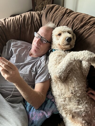 2 Goldendoodles Looking Up At A Camera In A House