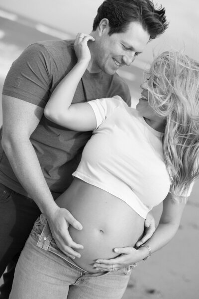 Couple facing each other while posing on the beach