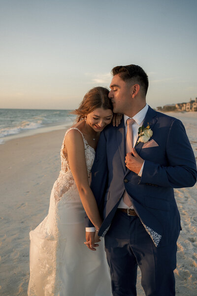 happy couple embracing on beach at sunset on their wedding day