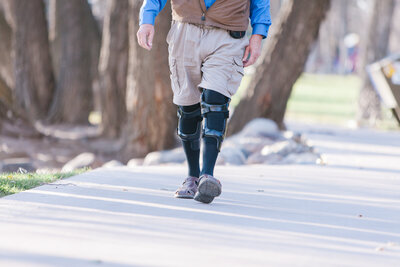 Elderly man with osteoarthritis walking comfortably with a knee brace