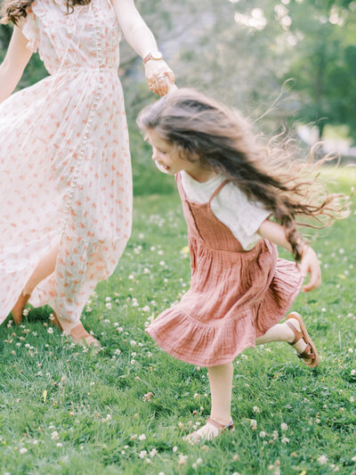 A girl holds to her mother's hand as she runs and her hair flies free around her | Pittsburgh Family Photographer | Anna Laero Photography