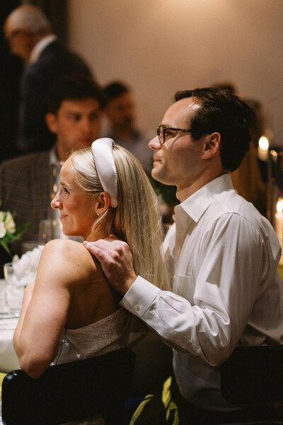 Film candid image of bride and groom listening to emotional toasts