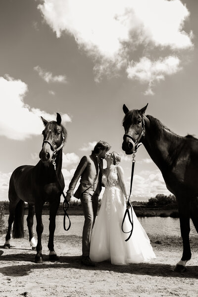 Vrouw zit met haar Samojeed op de grond in het zand