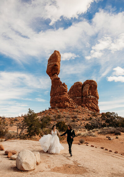 couple surrounded by big blue skies and rock formations