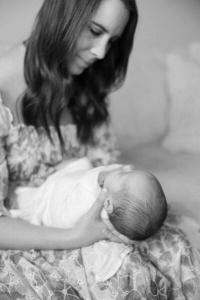 new mom admiring her swaddled newborn