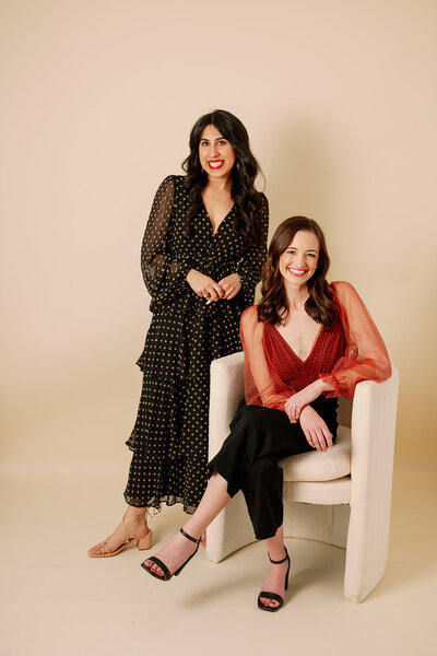 Woman sitting in a white chair with another woman standing beside her