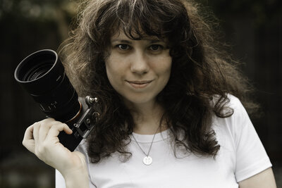 Thistle and Blooms Photographer poses with camera during branding session for her business as an Edmonds Newborn Photographer