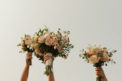 bridesmaids holding up bouquets on wedding day in pei