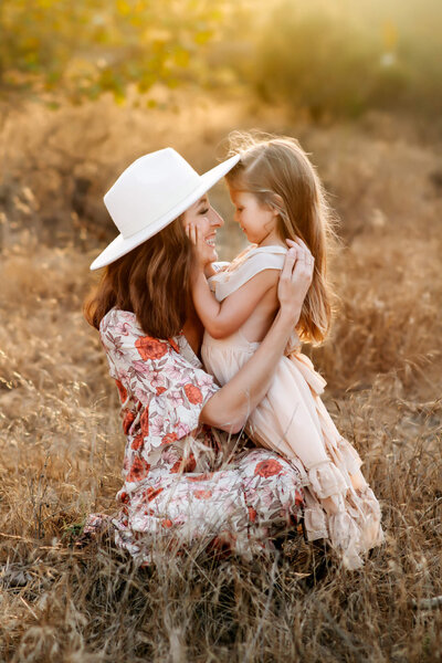 A photograph of a mother and daughter embracing one another in a field in Marian Bear Memorial Park in San Diego