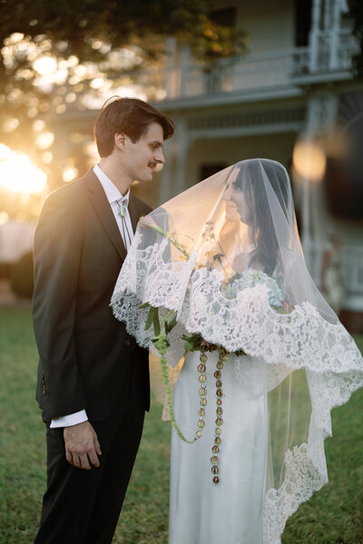 Elegant wedding photography at Barr Mansion, showcasing a bride and groom in a soft, dreamy sunset moment with vintage-inspired lace details.