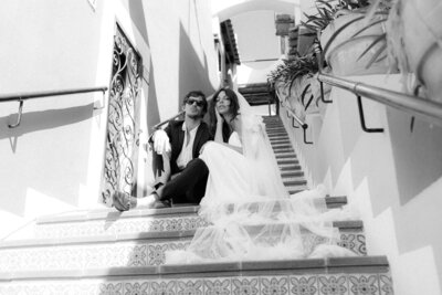 Modernes Editorial Wedding Portrait mit Schleier und Sonnenbrille auf dekorativer Steintreppe