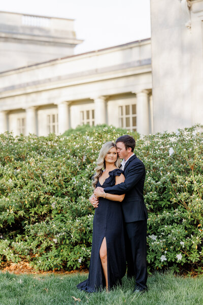 couple embracing infront of flowering bush