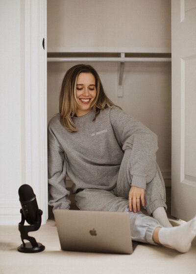 woman in sweats with laptop