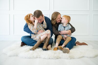 Fort Worth family photo session at the Lumen Room with a family of four whispering to each other.