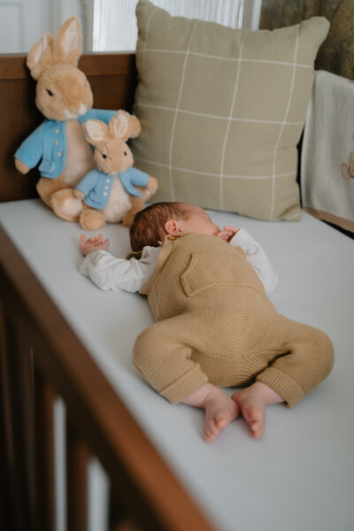 Cozy in-home newborn photo of baby boy in crib by Kansas City family and wedding photographer Emma Leigh Photo