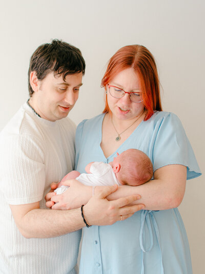 A mother and father hold their newborn baby during a photoshoot in my studio in Amsterdam West.