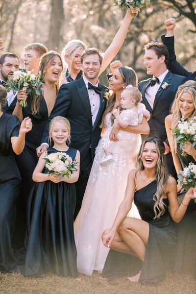 Bride and groom are surrounded by their wedding party for a portrait