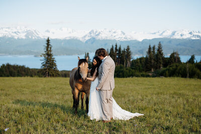 bride and groom standing by horse