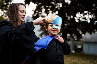 DOCUMENTARY-FAMILY-PHOTOGRAPHY-LA CROSSE-WISCONSIN - MOM HELPING SON PUT SUPER HERO MASK ON